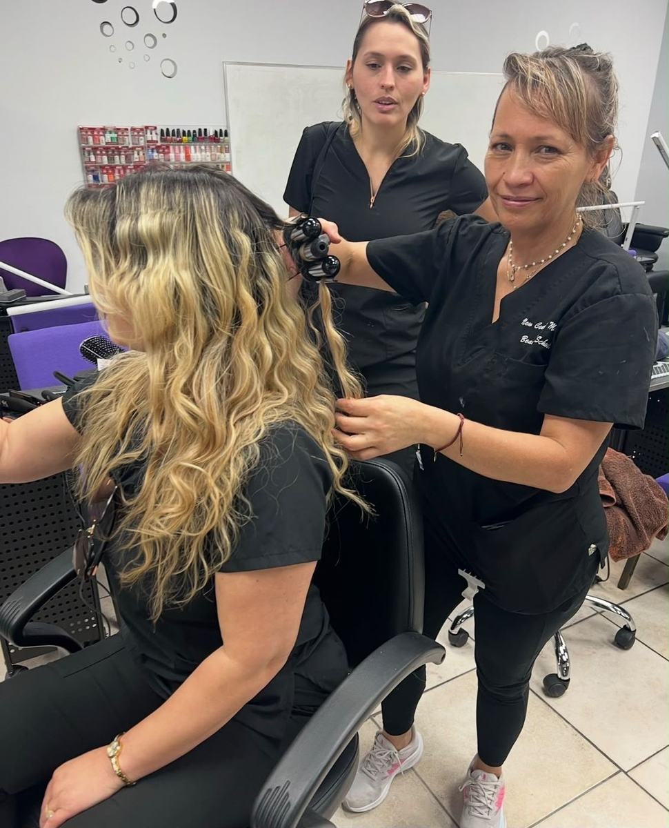 An instructor curling a student's hair during a class