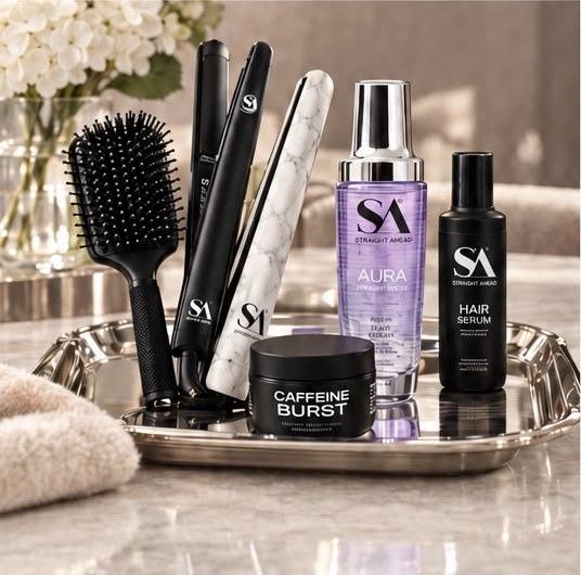 Straight Ahead flat irons, brush, Aura serum, hair serum and Caffeine Burst mask on a tray